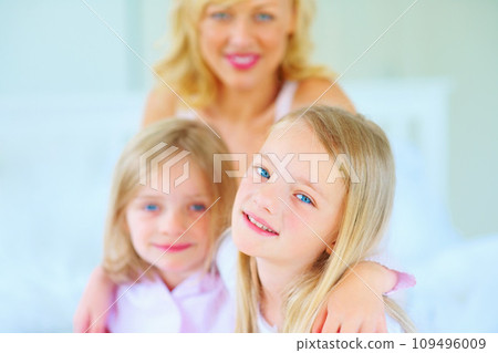 Smile, portrait and mother with children on bed for bonding, relaxing and spending time together. Happy, love and young mom chilling and resting with girl kids from Australia in bedroom of house. 109496009