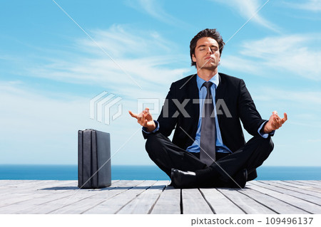 Meditation, briefcase and business man on blue sky for relaxing, positive mindset and solution. Corporate person, thinking and worker outdoors in yoga pose for mental health in career, work and job Meditation, briefcase and business man on blue sky for relaxing, positive mindset and solution. Corporate person, thinking and worker outdoors in yoga pose for mental health in career, work and job 109496137