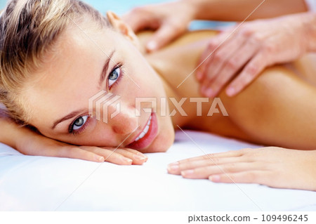 Woman, portrait and smile at spa for back massage wellness cosmetics or holistic therapy at holiday resort. Beauty salon, skincare and face of client relax for shoulder treatment, healing or vacation 109496245