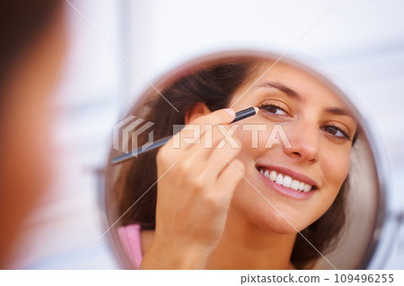 Mirror, makeup and happy woman with eyeliner, pencil or application in a home bathroom with morning routine. Face, beauty and female person with eye, color or shape, aesthetic or cosmetic treatment 109496255