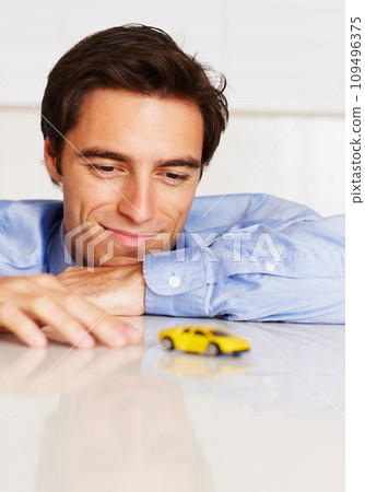Toy car, business and man with a smile, office and employee with happiness, cheerful or entrepreneur. Person, agent or consultant playing with vehicle, break or relax with peace, professional or calm Toy car, business and man with a smile, office and employee with happiness, cheerful or entrepreneur. Person, agent or consultant playing with vehicle, break or relax with peace, professional or calm 109496375
