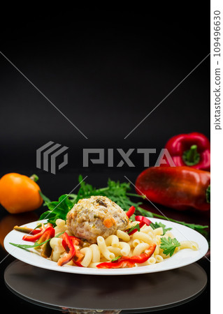 cooked pasta with meatballs, peppers and herbs with spices in a plate cooked pasta with meatballs, peppers and herbs with spices in a plate 109496630