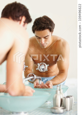 Man, face and water for washing in bathroom for facial hygiene, bacteria and germs. Male person, hands and basin by soap for dermatology, skincare or morning routine by grooming, health and wellness Man, face and water for washing in bathroom for facial hygiene, bacteria and germs. Male person, hands and basin by soap for dermatology, skincare or morning routine by grooming, health and wellness 109496822