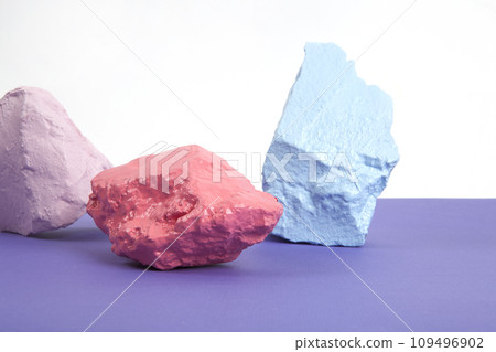 paint pebbles in pink, salmon and blue pastel shades isolated on a white and violet background. paint pebbles in pink, salmon and blue pastel shades isolated on a white and violet background. 109496902