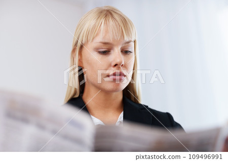 Young businesswoman, morning and newspaper for reading headlines on media and thinking in living room. Professional consultant, relax and positive idea with health wellness and current events in home 109496991