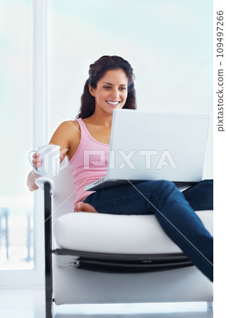 Woman, happy and coffee with laptop with reading digital blog and relax wellness in chair in home. Young person, smile and computer with espresso for online subscription and technology in apartment 109497266