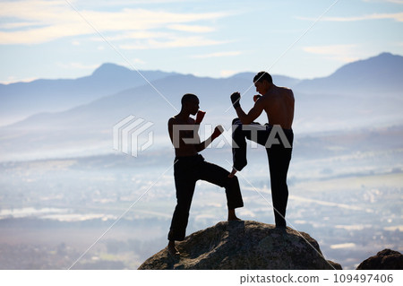Extreme kickboxing. A male kickboxer practising their technique on a mountain peak. 109497406