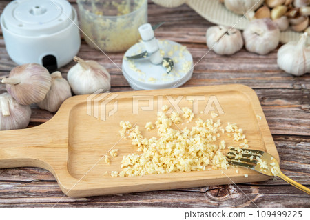 Garlic from a fine blender on a wooden plate 109499225