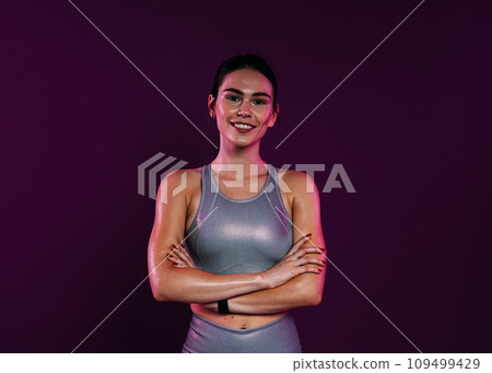 Portrait of a smiling confident sportswoman in silver fitness wear Portrait of a smiling confident sportswoman in silver fitness wear 109499429