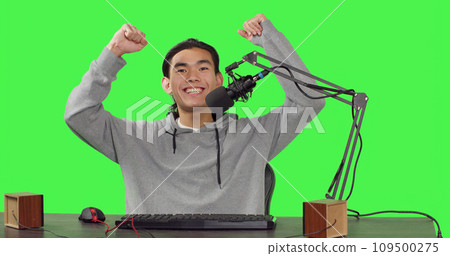 POV of content creator on live stream recording gameplay of new action video game launched, greenscreen backdrop. Asian streamer broadcasting multiplayer competition, streaming with microphone. POV of content creator on live stream recording gameplay of new action video game launched, greenscreen backdrop. Asian streamer broadcasting multiplayer competition, streaming with microphone. 109500275