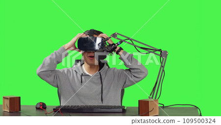 POV of broadcaster using virtual reality eyewear to stream live action gaming while sitting at workstation playing web sports. Media producer records arcade broadcast using vr headset. POV of broadcaster using virtual reality eyewear to stream live action gaming while sitting at workstation playing web sports. Media producer records arcade broadcast using vr headset. 109500324