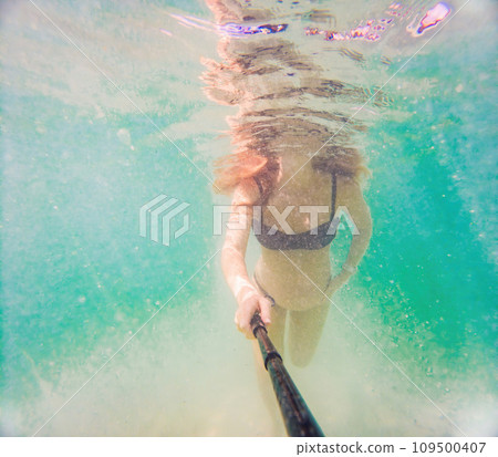 In an ethereal underwater scene, a pregnant woman gracefully floats, embodying the beauty of maternity beneath the tranquil surface of the sea In an ethereal underwater scene, a pregnant woman gracefully floats, embodying the beauty of maternity beneath the tranquil surface of the sea 109500407