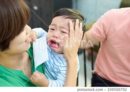 Crying baby and parents holding each other 109500792