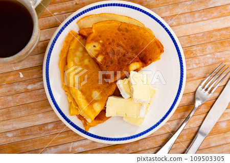 On plate - ruddy soft pancakes with pieces of tender cream brie cheese On plate - ruddy soft pancakes with pieces of tender cream brie cheese 109503305