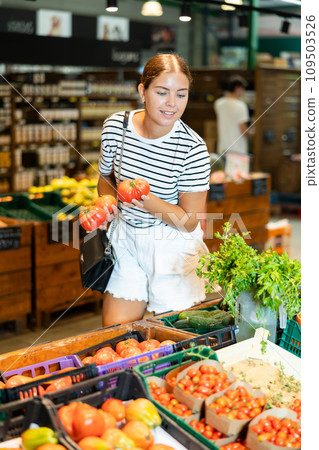 Young woman choosing tomatoes in grocery store 109503526