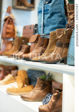 On brightly lit white shelves of store there are various variants of women shoes On brightly lit white shelves of store there are various variants of women shoes 109503567