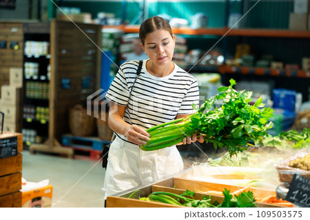 Young woman choosing celery in grocery store Young woman choosing celery in grocery store 109503575
