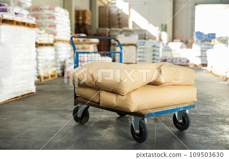 Bags are stacked on top of each other and lie in stacks in warehouse of building materials store. Bags are stacked on top of each other and lie in stacks in warehouse of building materials store. 109503630