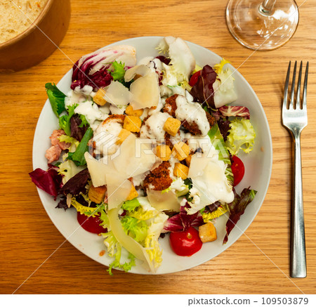 Variation of Caesar salad with chicken, lettuce mix and crackers 109503879