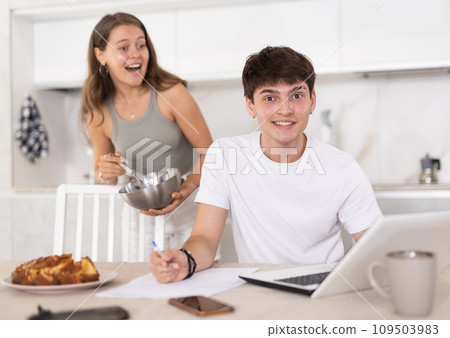 Young woman smiling and chatting with guy working at laptop Young woman smiling and chatting with guy working at laptop 109503983