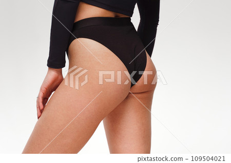 A woman with a beautiful feminine figure in black lingerie with overweight, cellulite and stretch marks. A woman with a beautiful feminine figure in black lingerie with overweight, cellulite and stretch marks. 109504021
