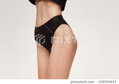 A woman with a beautiful feminine figure in black lingerie with overweight, cellulite and stretch marks. A woman with a beautiful feminine figure in black lingerie with overweight, cellulite and stretch marks. 109504034