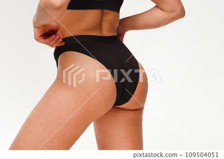 A woman with a beautiful feminine figure in black lingerie with overweight, cellulite and stretch marks. A woman with a beautiful feminine figure in black lingerie with overweight, cellulite and stretch marks. 109504051