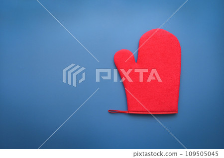 red wool winter glove on blue background, christmas decoration red wool winter glove on blue background, christmas decoration 109505045