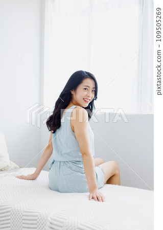 A woman standing by the window in the morning 109505269