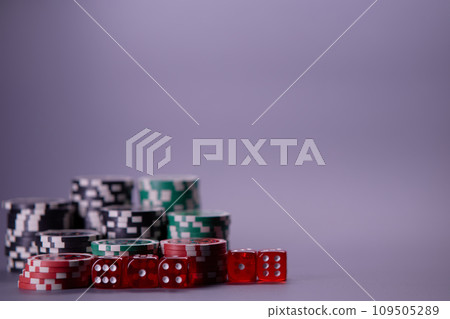 Casino games and gambling concept with stacked poker chips and red dice used in the game of craps. Copy space. Casino games and gambling concept with stacked poker chips and red dice used in the game of craps. Copy space. 109505289