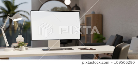 A white-screen PC computer mockup, a table lamp, and accessories on a white desk in a modern room. A white-screen PC computer mockup, a table lamp, and accessories on a white desk in a modern room. 109506290