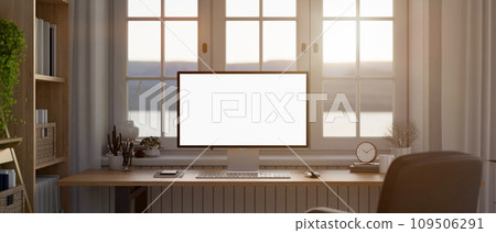 Modern home workstation, a PC computer white screen mockup on a wooden desk against the window. 109506291