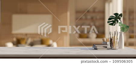 A creative workspace with books, painting tools, and empty mockup space on a tabletop. 109506305