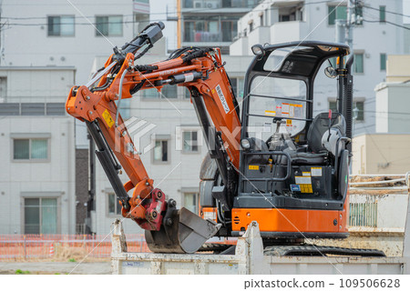 A loader dump (cargo platform) carrying a mini excavator 109506628