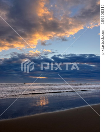 The shore of the Pacific Ocean at sunrise with many clouds 109508313