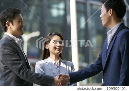 asian business people shaking hands outdoors 109509401