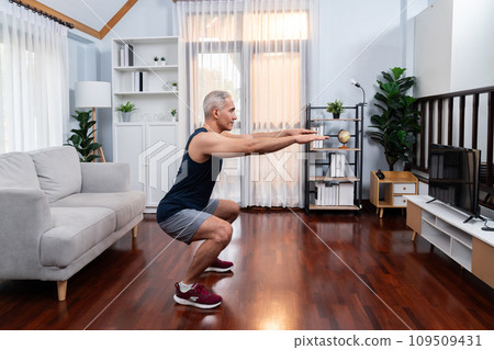 Active and fit senior man warmup and stretching before home exercising. Clout 109509431