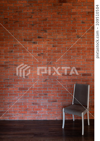 One vintage chair against an old brick wall in the interior 109510584