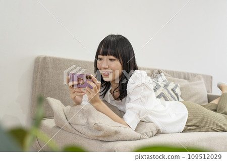 一個女人在家放鬆並操作智慧型手機 一個女人在家放鬆並操作智慧型手機 109512029