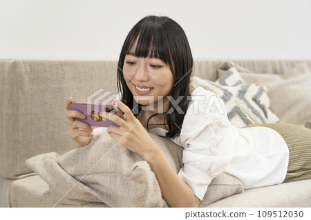一個女人在家放鬆並操作智慧型手機 一個女人在家放鬆並操作智慧型手機 109512030