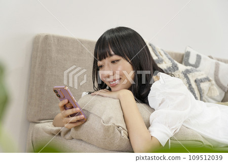 一個女人在家放鬆並操作智慧型手機 一個女人在家放鬆並操作智慧型手機 109512039