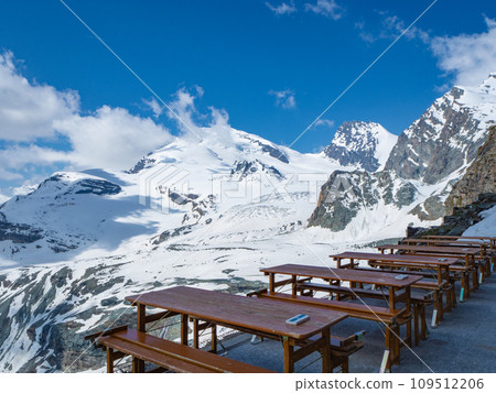Saas-Fee, Switzerland - June 16th 2023: View from the terrace of Britanniahuette towards wide glaciers and peaks 109512206