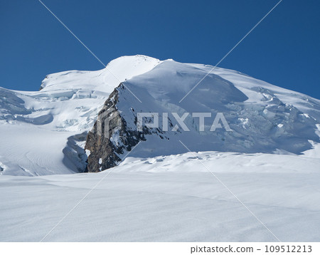 Saas-Fee, Switzerland - June 16th 2023: View back to Strahlhorn peak over wide glacier landscapes. Saas-Fee, Switzerland - June 16th 2023: View back to Strahlhorn peak over wide glacier landscapes. 109512213