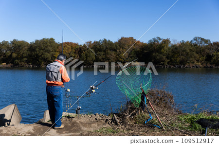 A man enjoying fishing in the river 109512917