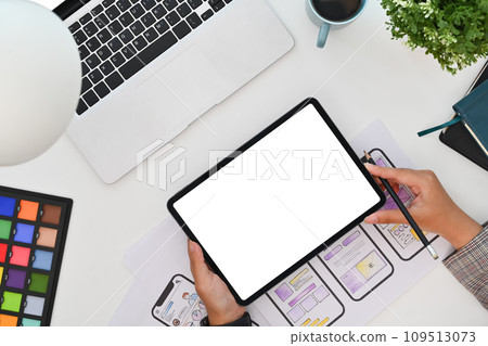 From above view of female designer working on development project for mobile application at desk From above view of female designer working on development project for mobile application at desk 109513073