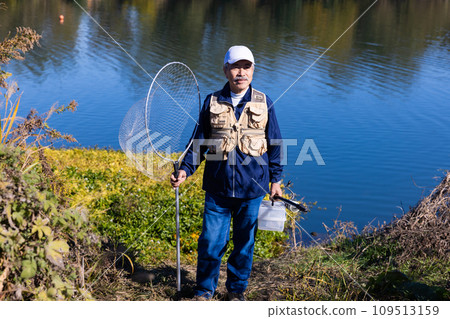 A man enjoying fishing as a hobby in the river A man enjoying fishing as a hobby in the river 109513159