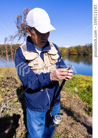 A man enjoying fishing as a hobby in the river A man enjoying fishing as a hobby in the river 109513165