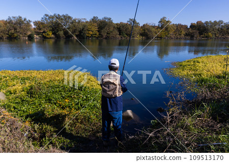 A man enjoying fishing as a hobby in the river A man enjoying fishing as a hobby in the river 109513170