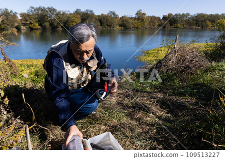 A man enjoying fishing in the river A man enjoying fishing in the river 109513227
