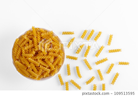 Pasta products in the form of a spiral on a plate, texture, on a white background Pasta products in the form of a spiral on a plate, texture, on a white background 109513595